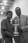 Dunbar High School coach Lester Beene presenting the Mayor's Sportsmanship Trophy to Eddie Tate