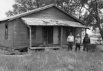 From left, Bill Lane, Harold Ham, and Chuck Martin stand in front of Bob Wills' old homeplace, Turkey, Texas