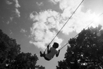 Children play on a swing set at Sycamore Park during Juneteenth festivities