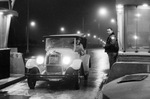 Sam Cook driving an antique automobile through idle toll gates after tolls are no longer being collected by Rodger Mallison