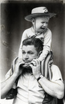 Kevin Brown, age 3, sits on father's shoulders during the Stock Show parade