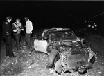 Automobile crash involving a Corvette in which one person was killed; police inspecting wrecked car, 11/30/1980 by Gene Gordon
