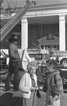 People standing outside watching while firefighters battle blaze by Willis Knight