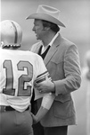 Cleburne High School football coach Chuck Curtis talks with player #12 during a game with Lubbock High School by Larry C. Price
