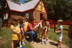 Barnyard Bob in front of gingerbread house in the petting zoo
