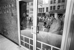 Bystanders inside the Praetorian Building watch Ku Klux Klan march in downtown Dallas by Joe Giron