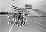 UTA football players carrying bleachers across Maverick Stadium by Tony Record