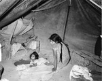 Woman and child on floor of tent who are ill but unable to have a doctor in Tampiquito, a camp south of Donna, Texas