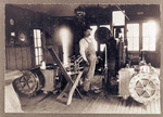 Hoisting engineer standing in shop next to large machinery