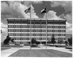 Completed six-story library at the University of Texas at Arlington; cars parked on street in front of building