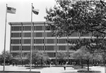 Completed six-story library at the University of Texas at Arlington; cars parked on street in front of building