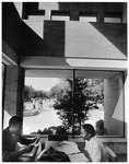 Two students sit by windows of Hereford Student Center