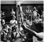 Olympic Torch being carried in front of crowd at UTA's Hereford Student Center