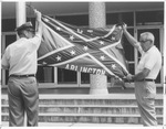 UTA Campus Policeman M. F. Britain lowers the Rebel Flag for last time