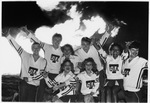 UTA cheerleaders beside bonfire