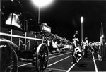 Crowd and cheerleaders with wagon and bell at UTA homecoming football game