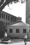 UTA's Roundhouse with water fountain and a student in front