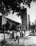 Students passing in front of the Roundhouse and fountain on the UTA campus