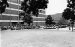 Arlington State College (A. S. C.) Library with students and cars parked in front