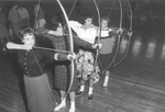 Arlington State College (A. S. C.), female archery students demonstrating bow and arrow