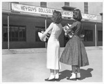 Arlington State College (A. S. C.) coeds looking at poster advertising the San Souci Club