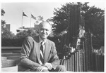 UTA President Wendell Nedderman seated beside fountain