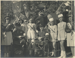 Photo of Warren C. Cowen and an unidentified man with cheerleaders
