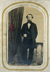 Bearded man standing beside curtain