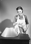 Woman cleaning lamp lightbulb by W. D. Smith