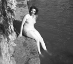 Young woman sitting on a rock ledge by W. D. Smith