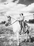 A young cowgirl sits on a horse by W. D. Smith