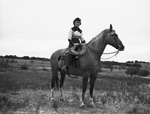 A young cowgirl is sitting on a horse by W. D. Smith