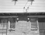 Electrical meters installed by the windows of a house by W. D. Smith