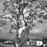 Young woman standing under a tree by W. D. Smith