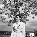 Young woman standing under a tree by W. D. Smith