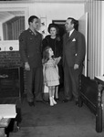 A family standing inside the front door of a home by W. D. Smith