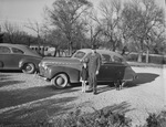 A young man in a military uniform with a child and a dog standing outside in front of an automobile by W. D. Smith