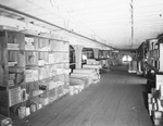 Interior of warehouse with aisles of stock by W. D. Smith