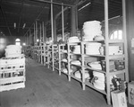 Interior of warehouse with aisles of stock by W. D. Smith