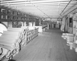 Interior of warehouse with aisles of stock by W. D. Smith