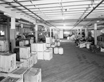 Interior of warehouse with aisles of stock by W. D. Smith