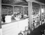 Interior of warehouse with aisles of stock by W. D. Smith