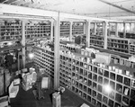 Interior of warehouse with aisles of stock by W. D. Smith