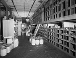 Interior of warehouse with aisles of stock by W. D. Smith