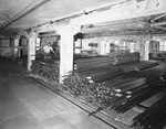 Interior of warehouse with aisles of pipe by W. D. Smith