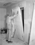 Ready Hung Doors--Man installing door by W. D. Smith