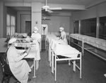 Physician and nurses attending infants in maternity ward by W. D. Smith