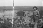 Man standing next to a field camera by W. D. Smith