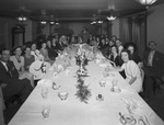 Group sitting at a dining table by W. D. Smith