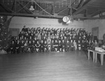 Group portrait of employees beside Christmas tree by W. D. Smith